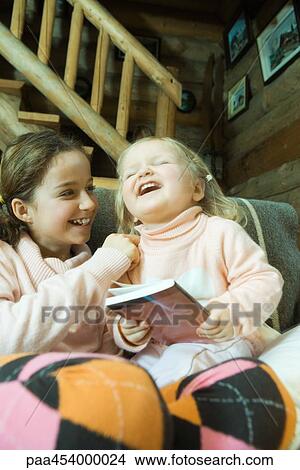 Girl and toddler sitting on couch, laughing View Large Photo Image Picture - Girl and toddler sitting on couch, laughing. Fotosearch