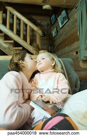 Girl and toddler sitting on couch, kissing cheek View Large Photo Image Stock Photo - Girl and toddler sitting on couch, kissing cheek. Fotosearch