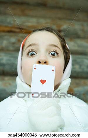Girl holding card over mouth, dressed in winter clothing, looking at camera, wide eyes View Large Photo Image Stock Photography - Girl holding card over mouth, dressed in winter clothing, looking at camera, wide eyes. Fotosearch