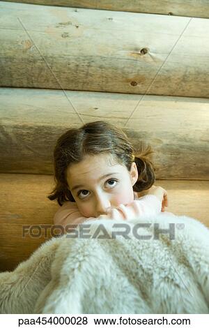 Girl sitting under blanket, looking up, portrait View Large Photo Image Stock Photo - Girl sitting under blanket, looking up, portrait. Fotosearch