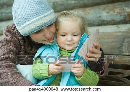 Teenage girl and toddler playing cards, dressed in winter clothing, cheek to cheek View Large Photo Image Stock Photo - Teenage girl and toddler playing cards, dressed in winter clothing, cheek to cheek. Fotosearch