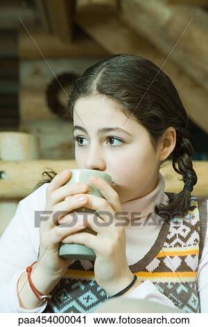 Teenage girl drinking hot beverage, looking away View Large Photo Image Stock Image - Teenage girl drinking hot beverage, looking away. Fotosearch