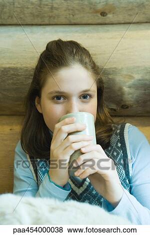 Teenage girl drinking hot beverage, looking at camera View Large Photo Image Stock Photo - Teenage girl drinking hot beverage, looking at camera. Fotosearch