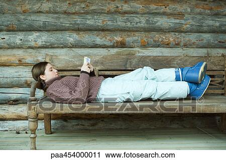 Teenage girl lying on back, reading book, wearing winter clothing View Large Photo Image Stock Image - Teenage girl lying on back, reading book, wearing winter clothing. Fotosearch