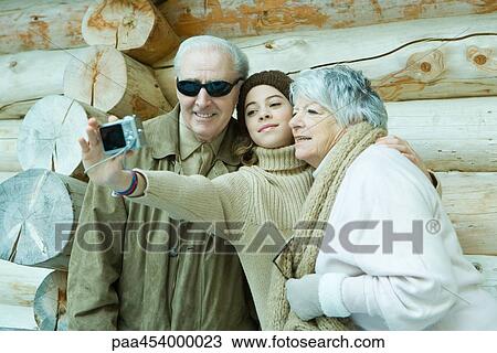 Teenage girl photographing self with grandparents View Large Photo Image Stock Image - Teenage girl photographing self with grandparents. Fotosearch