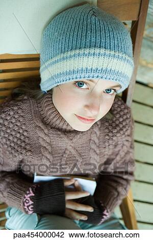 Teenage girl smiling at camera, dressed in winter clothing, high angle view View Large Photo Image Stock Image - Teenage girl smiling at camera, dressed in winter clothing, high angle view. Fotosearch