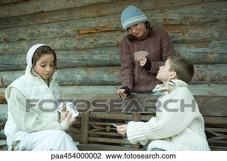 Young friends playing cards outdoors, dressed in winter clothing View Large Photo Image Stock Image - Young friends playing cards outdoors, dressed in winter clothing. Fotosearch