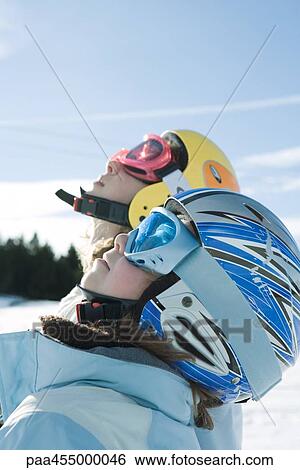 Two young skiers looking up, side view, head and shoulders View Large Photo Image Stock Photograph - Two young skiers looking up, side view, head and shoulders. Fotosearch