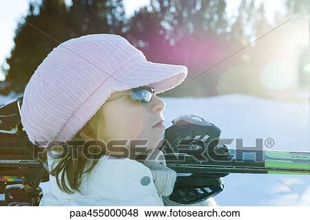 Young female skier holding skis on shoulder, side view, looking away View Large Photo Image Stock Photo - Young female skier holding skis on shoulder, side view, looking away. Fotosearch