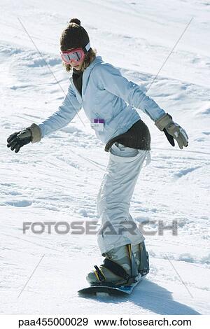 Young female snowboarder on ski slope, side view, full length View Large Photo Image Stock Photo - Young female snowboarder on ski slope, side view, full length. Fotosearch