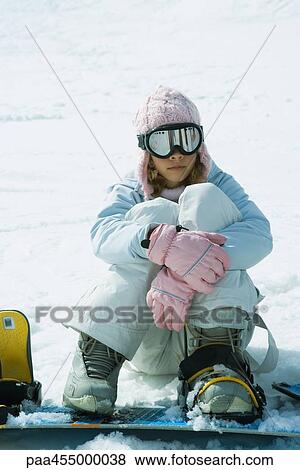 Young female snowboarder sitting on ground, hugging knees View Large Photo Image Stock Photo - Young female snowboarder sitting on ground, hugging knees. Fotosearch