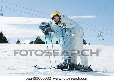 Young skiers bending over together, smiling at camera, full length portrait View Large Photo Image Stock Image - Young skiers bending over together, smiling at camera, full length portrait. Fotosearch