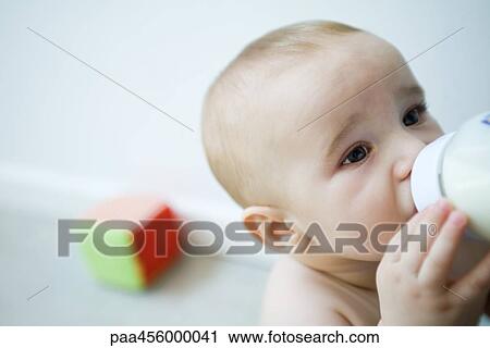 Baby drinking milk from bottle, looking away, head and shoulders View Large Photo Image Stock Image - Baby drinking milk from bottle, looking away, head and shoulders. Fotosearch