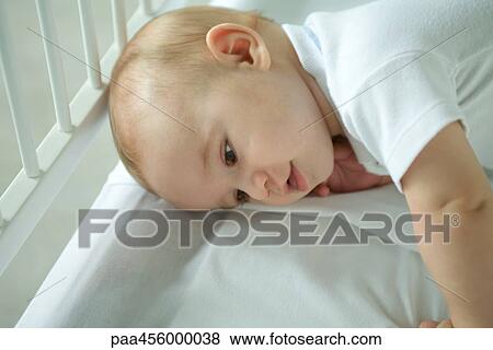 Baby in crib, lying on side, head and shoulders View Large Photo Image Stock Photo - Baby in crib, lying on side, head and shoulders. Fotosearch