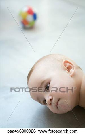 Baby lying on floor, head, close-up View Large Photo Image Stock Photograph - Baby lying on floor, head, close-up. Fotosearch