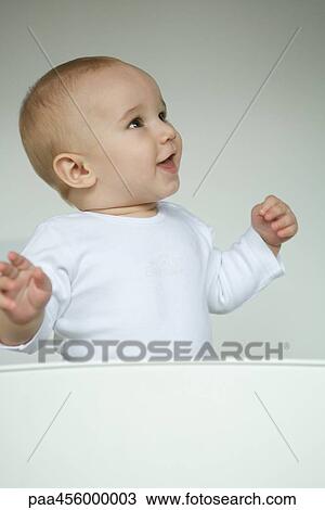 Baby smiling, looking away, waist up View Large Photo Image Stock Image - Baby smiling, looking away, waist up. Fotosearch