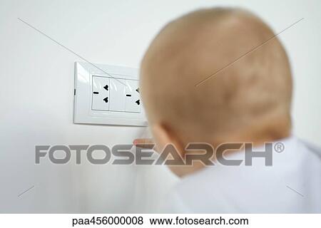 Baby touching electric outlet, rear view View Large Photo Image Stock Photo - Baby touching electric outlet, rear view. Fotosearch