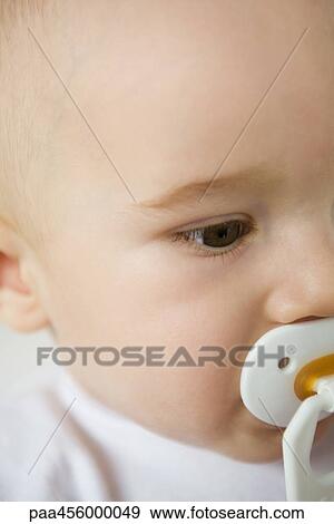 Stock Photo - Baby with pacifier, cropped view of face. Fotosearch