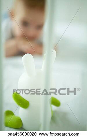 Toy rabbit, rear view, baby in background View Large Photo Image Stock Image - Toy rabbit, rear view, baby in background. Fotosearch