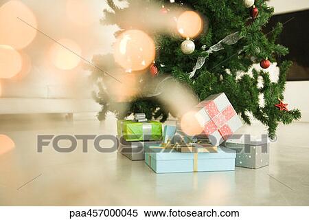 Christmas presents stacked beneath Christmas tree, view through Christmas lights, selective focus View Large Photo Image Stock Photography - Christmas presents stacked beneath Christmas tree, view through Christmas lights, selective focus. Fotosearch