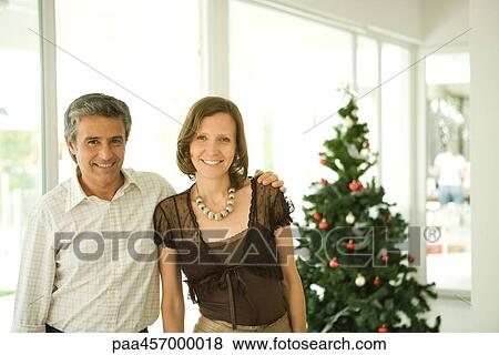 Mature couple, portrait in front of Christmas tree View Large Photo Image Stock Photo - Mature couple, portrait in front of Christmas tree. Fotosearch