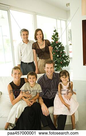 Stock Image - Three generation family, group portrait in front of Christmas tree. Fotosearch