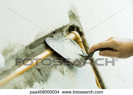 Man applying putty to pipe, cropped view of hand View Large Photo Image Picture - Man applying putty to pipe, cropped view of hand. Fotosearch