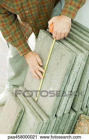 Man measuring paving stone with measuring tape, cropped view View Large Photo Image Stock Image - Man measuring paving stone with measuring tape, cropped view. Fotosearch