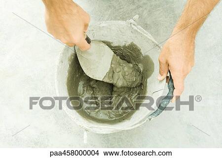 Picture - Man preparing putty, cropped view of hands. Fotosearch