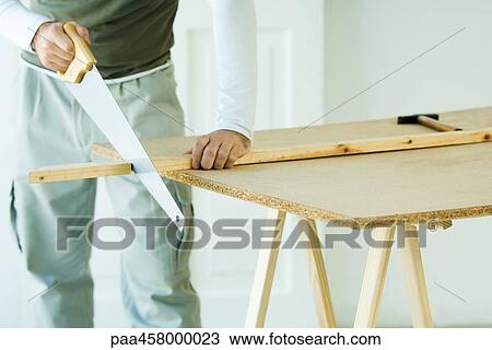 Man sawing wood with saw, cropped view View Large Photo Image Stock Image - Man sawing wood with saw, cropped view. Fotosearch