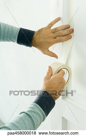 Man taping door with adhesive tape, cropped view of hands View Large Photo Image Stock Photo - Man taping door with adhesive tape, cropped view of hands. Fotosearch