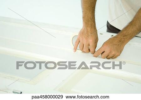 Man taping door with adhesive tape, cropped view of hands View Large Photo Image Stock Photo - Man taping door with adhesive tape, cropped view of hands. Fotosearch