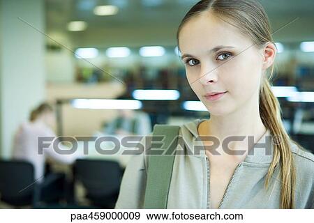 Stock Photo - Female student smiling at camera, sideways glance. Fotosearch