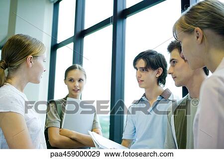 Group of students standing by window, chatting, waist up View Large Photo Image Stock Photo - Group of students standing by window, chatting, waist up. Fotosearch