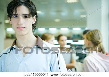 Male student smiling at camera, portrait, peers in background View Large Photo Image Stock Image - Male student smiling at camera, portrait, peers in background. Fotosearch