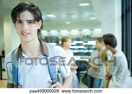 Male student wearing backpack, smiling at camera, portrait View Large Photo Image Stock Photo - Male student wearing backpack, smiling at camera, portrait. Fotosearch