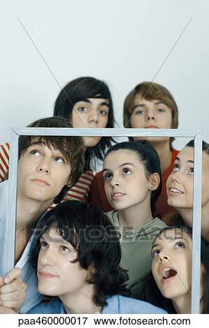 Group of young friends holding up picture frame, portrait View Large Photo Image Stock Photo - Group of young friends holding up picture frame, portrait. Fotosearch