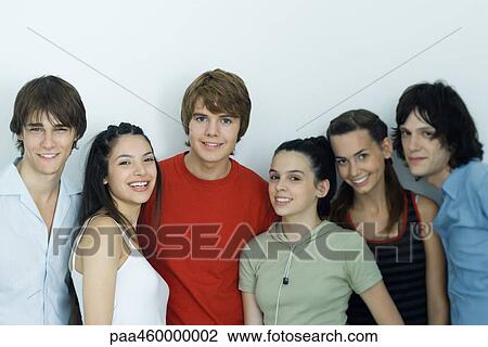 Stock Image - Group of young friends posing for photo, smiling at camera, waist up. Fotosearch