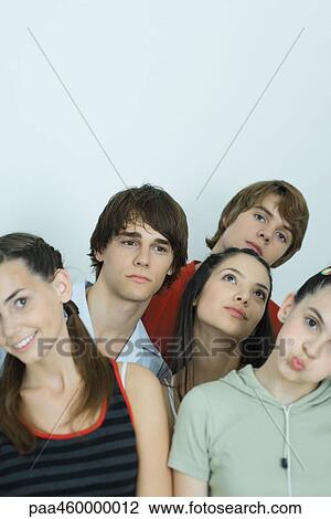 Stock Image - Group of young friends posing for photo, heads tilted, portrait. Fotosearch