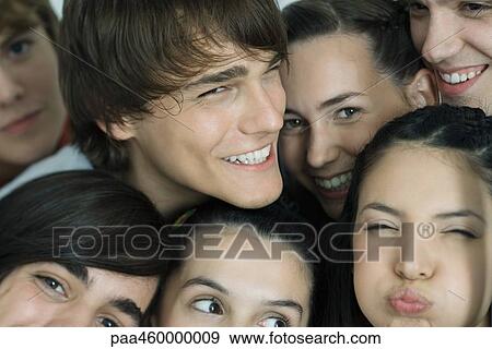 Stock Photo - Group of young friends posing for photo, smiling at camera, full frame, close-up, portrait. Fotosearch
