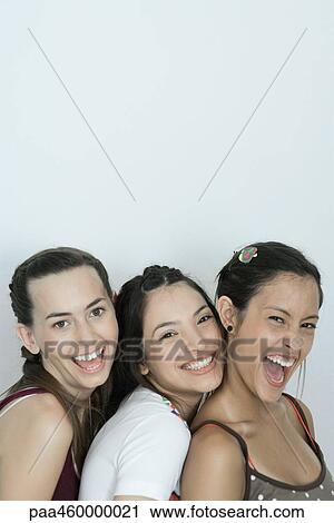 Three young female friends smiling at camera, head and shoulders, portrait View Large Photo Image Stock Image - Three young female friends smiling at camera, head and shoulders, portrait. Fotosearch