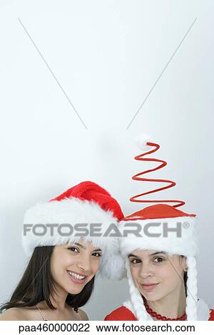 Two young female friends dressed in Christmas costumes, smiling at camera, head and shoulders, portrait View Large Photo Image Stock Image - Two young female friends dressed in Christmas costumes, smiling at camera, head and shoulders, portrait. Fotosearch