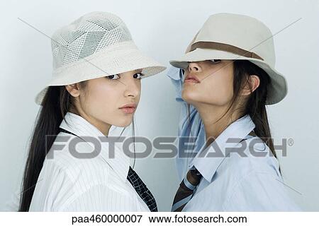 Two young female friends dressed in button down shirts, ties and hats, looking at camera, portrait View Large Photo Image Stock Photo - Two young female friends dressed in button down shirts, ties and hats, looking at camera, portrait. Fotosearch