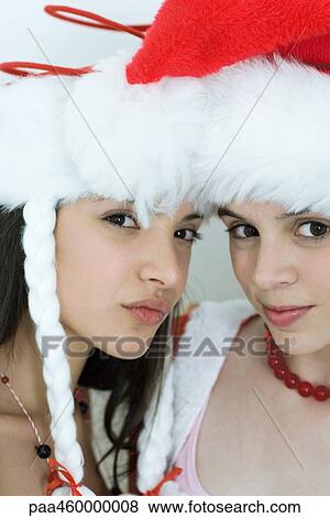 Stock Photo - Two young female friends dressed in Christmas costumes, looking at camera, portrait. Fotosearch