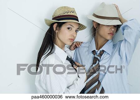 Two young female friends dressed in button down shirts, ties and hats, portrait View Large Photo Image Stock Photograph - Two young female friends dressed in button down shirts, ties and hats, portrait. Fotosearch