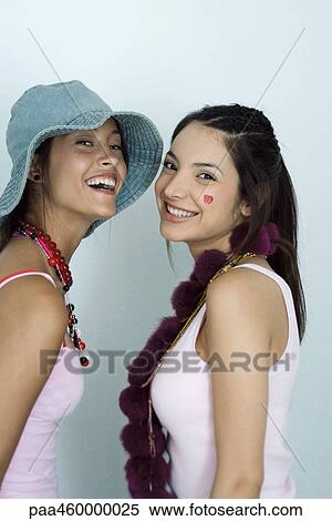 Two young female friends, smiling at camera, portrait View Large Photo Image Stock Photography - Two young female friends, smiling at camera, portrait. Fotosearch
