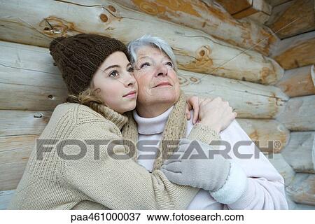 Granddaughter and grandmother embracing, looking up, portrait View Large Photo Image Stock Photo - Granddaughter and grandmother embracing, looking up, portrait. Fotosearch