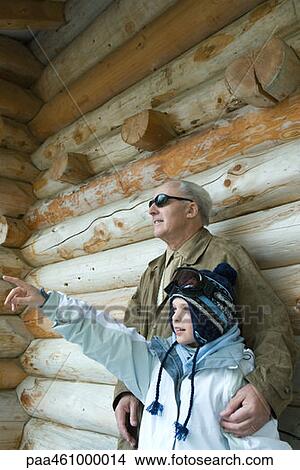 Picture - Grandfather and grandson standing together, boy pointing, both looking away. Fotosearch