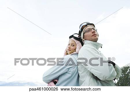 Teen girl and young man in ski gear, standing back to back, arms folded, smiling, girl looking at camera View Large Photo Image Stock Photograph - Teen girl and young man in ski gear, standing back to back, arms folded, smiling, girl looking at camera. Fotosearch