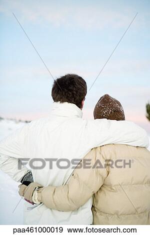Two unrecognizable people standing together, embracing, dressed in winter clothing, rear view View Large Photo Image Stock Photo - Two unrecognizable people standing together, embracing, dressed in winter clothing, rear view. Fotosearch